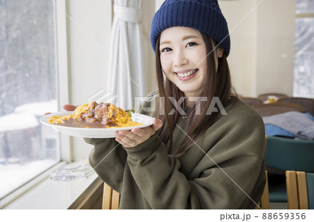 スキー場のレストランで食事をする若い女性 88659356
