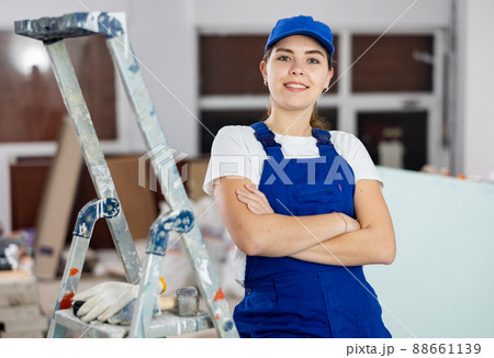 Smiling woman repairer standing inside apartment 88661139