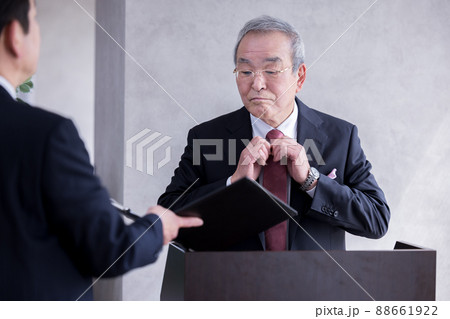 ビジネス　演説の前に部下と打合せをするシニア男性 88661922