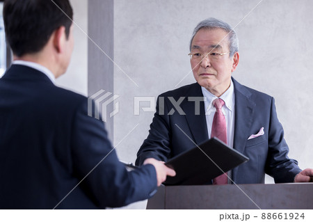 ビジネス　演説の前に部下と打合せをするシニア男性 88661924