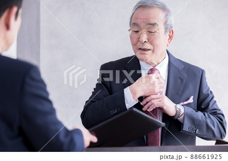 ビジネス　演説の前に部下と打合せをするシニア男性 88661925