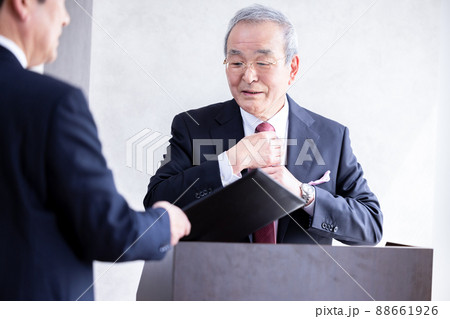 ビジネス　演説の前に部下と打合せをするシニア男性 88661926