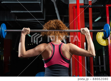 Woman bodybuilder engaged with a barbell in the gym Woman bodybuilder engaged with a barbell in the gym 88662080