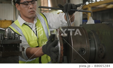 professional mechanical operation man wear uniform hardhat and goggles safety workers are tightening bolts on workshop professional mechanical operation man wear uniform hardhat and goggles safety workers are tightening bolts on workshop 88665284