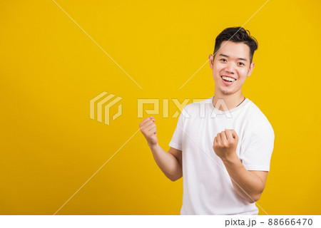 young man smiling positive shaking hands enthusiastic shouting yes young man smiling positive shaking hands enthusiastic shouting yes 88666470