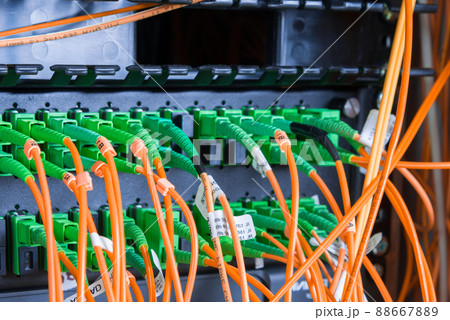 fiber optic cables plugged in network switch panel inside data center 88667889