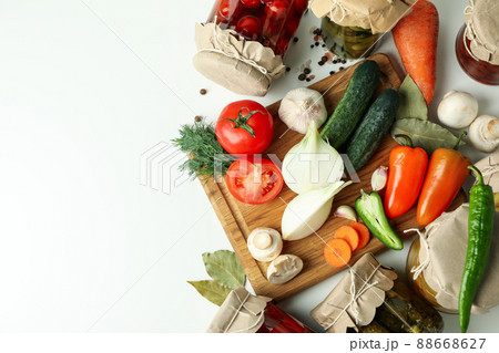 Jars of pickled vegetables and ingredients on white table Jars of pickled vegetables and ingredients on white table 88668627