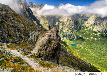 Hiker standing on the hill and looking on mountains Hiker standing on the hill and looking on mountains 88669648
