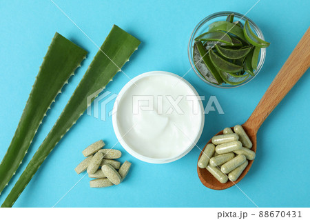 Concept of herb pills and cosmetics with aloe on blue background Concept of herb pills and cosmetics with aloe on blue background 88670431