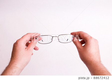 Glasses for vision in hands on gray background 88672412
