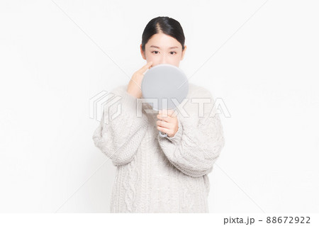 鏡を見て肌のチェックをする女性 88672922