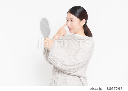 鏡を見て肌のチェックをする女性 88672924