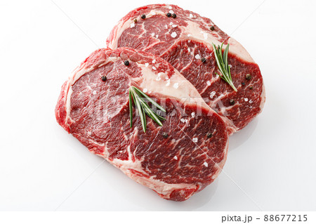 Ribeye steak top view. Raw meat with spices isolated on white background Ribeye steak top view. Raw meat with spices isolated on white background 88677215