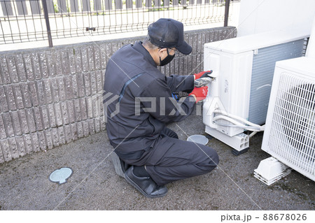 エアコンの撤収作業で室外機を外す作業員 エアコンの撤収作業で室外機を外す作業員 88678026