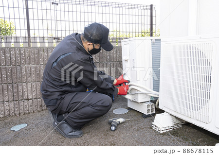 エアコンの撤収作業で室外機を外す作業員 エアコンの撤収作業で室外機を外す作業員 88678115