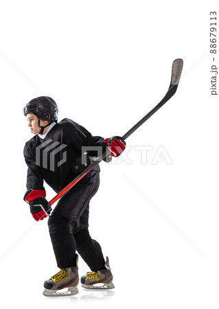 Side view. Portrait of concentrated boy, child, hockey player in motion, training isolated over white background. 88679113