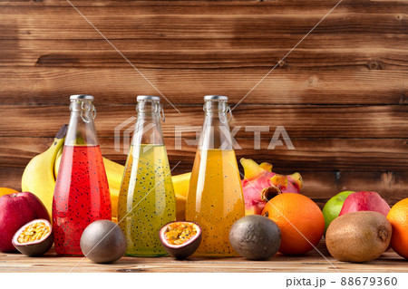 Fruit drink in glass bottle and frsh fruits on wooden background Fruit drink in glass bottle and frsh fruits on wooden background 88679360
