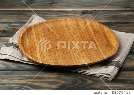 Wooden board with kitchen napkin on dark wooden table Wooden board with kitchen napkin on dark wooden table 88679415