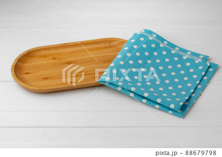 Wooden cutting board on cotton napkin on white wooden table 88679798