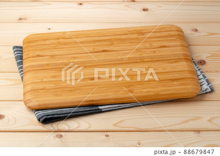 Cutting board with cotton napkin on wooden table 88679847