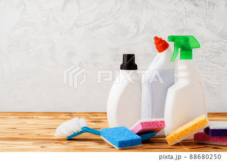 Household cleaning detergents on wooden table against gray background Household cleaning detergents on wooden table against gray background 88680250