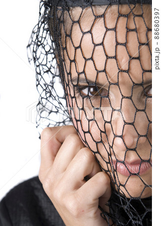 widowed woman dressed in black mourning her husband.  88680397