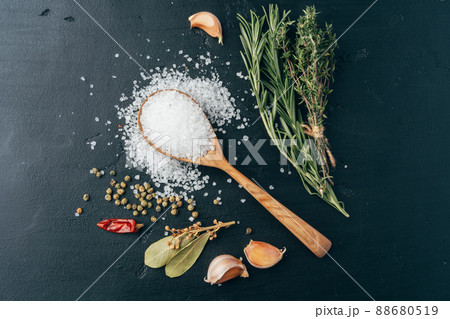 Wooden spoon and different spices on black background Wooden spoon and different spices on black background 88680519