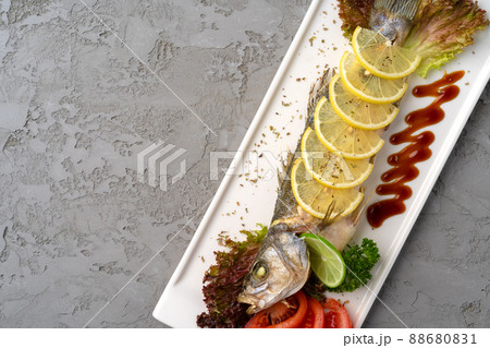 Fresh sea fish with lemon on plate Fresh sea fish with lemon on plate 88680831