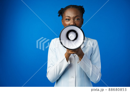 Afro american female doctor in white medical gown scream in megaphone in studio Afro american female doctor in white medical gown scream in megaphone in studio 88680853