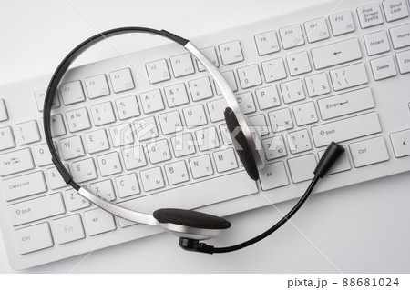 Headset on a laptop keyboard on office table Headset on a laptop keyboard on office table 88681024