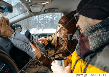 Family couple sitting in car in winter clothes iin snow forest 88681214