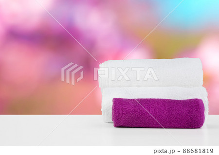 Stacked white spa towels on table against blurred background 88681819