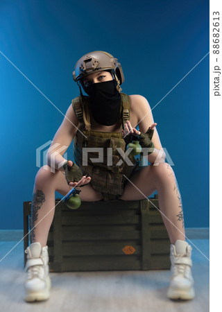 sexy girl soldier in helmet and bulletproof vest in military clothes with grenades posing in the studio 88682613