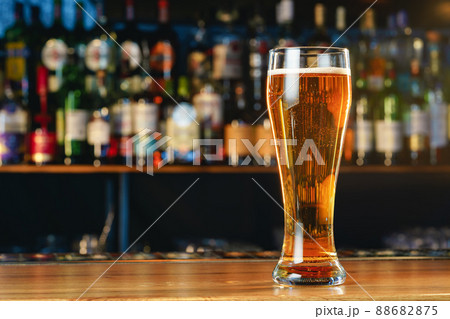 Fresh cold beer in glass on bar background Fresh cold beer in glass on bar background 88682875
