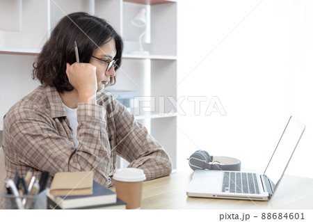 Young studying online uses his laptop in a live performance to communicate with his friends and teachers, Using laptops and data graphs in class, Online communication, Social distancing. Young studying online uses his laptop in a live performance to communicate with his friends and teachers, Using laptops and data graphs in class, Online communication, Social distancing. 88684601