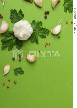 Garlic, parsley and spices on green background 88685192