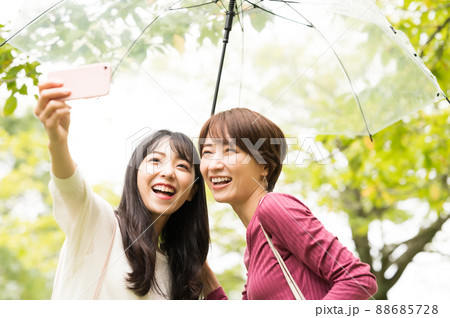 雨の旅行で自撮りをする二人の女性 88685728