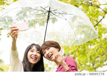 雨の旅行で自撮りをする二人の女性 88685779