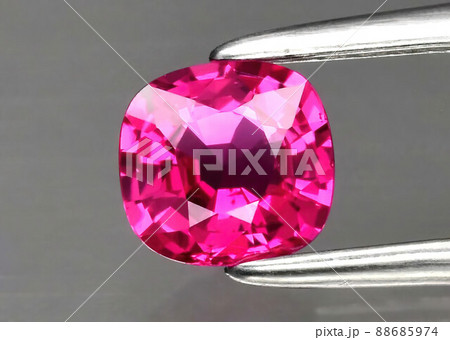 Natural gemstone red ruby in tongs on a gray background 88685974