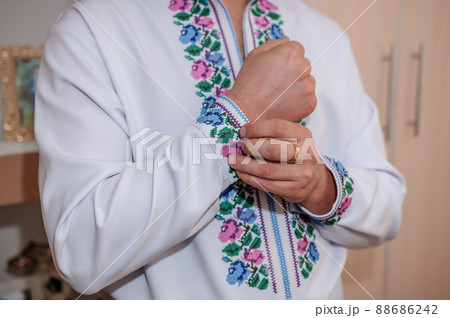 The groom fastens a button on the sleeve of his shirt The groom fastens a button on the sleeve of his shirt 88686242