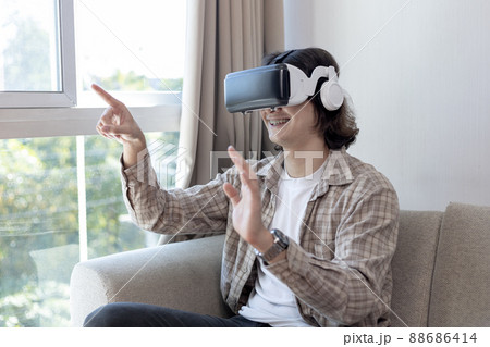 Man wearing virtual reality glasses is playing a 3D game with excitement, Man in glasses of virtual reality, VR, Future games, Gadgets, Technology, White background , VR game concept.  88686414