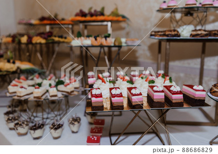 Sweet cakes at a wedding banquet. Catering, sweet festive buffet. Candy bar Sweet cakes at a wedding banquet. Catering, sweet festive buffet. Candy bar 88686829