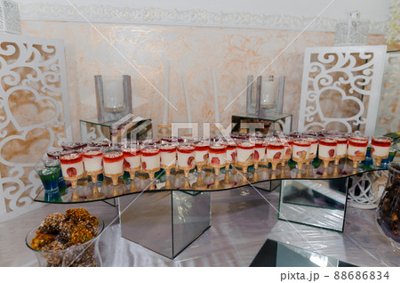 Sweet cakes at a wedding banquet. Catering, sweet festive buffet. Candy bar Sweet cakes at a wedding banquet. Catering, sweet festive buffet. Candy bar 88686834