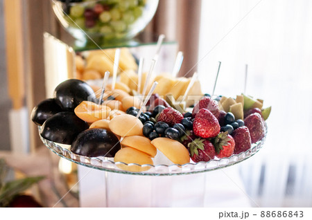 Fruit slicing at a wedding banquet. Watermelon, grapes, strawberry, orange, plum, pear, dinha, peach, kiwi, pineapple, persimmon, apple 88686843