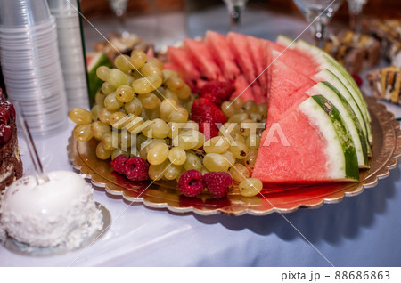 Fruit slicing at a wedding banquet. Watermelon, grapes, strawberry, orange, plum, pear, dinha, peach, kiwi, pineapple, persimmon, apple Fruit slicing at a wedding banquet. Watermelon, grapes, strawberry, orange, plum, pear, dinha, peach, kiwi, pineapple, persimmon, apple 88686863