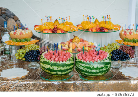 Fruit slicing at a wedding banquet. Watermelon, grapes, strawberry, orange, plum, pear, dinha, peach, kiwi, pineapple, persimmon, apple Fruit slicing at a wedding banquet. Watermelon, grapes, strawberry, orange, plum, pear, dinha, peach, kiwi, pineapple, persimmon, apple 88686872