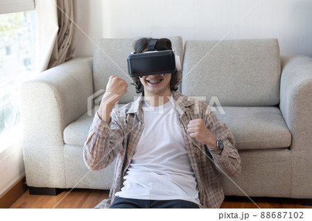 Man wearing virtual reality glasses is playing a 3D game with excitement, Man in glasses of virtual reality, VR, Future games, Gadgets, Technology, White background , VR game concept.  88687102