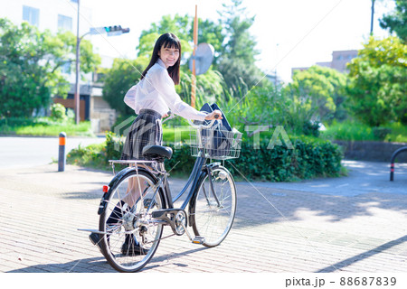 笑顔であいさつする、自転車通学する女子高校生　住宅地　市街地　綺麗な新緑 88687839
