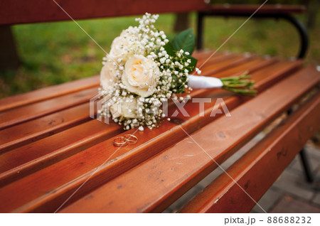 Beautiful bridal bouquet of flowers. Wedding rings on the bride's bouquet. Bridal bouquet close up 88688232