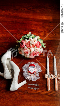 Morning of the bride. Bridal bouquet. Wedding candles in the church. Wedding rings in a red box. White shoes of the bride. Garter on the leg of the bride. Bridal accessories 88688242